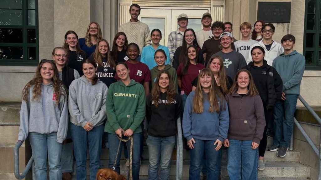 A group of college students posing for a photo on a staircase outside of a building