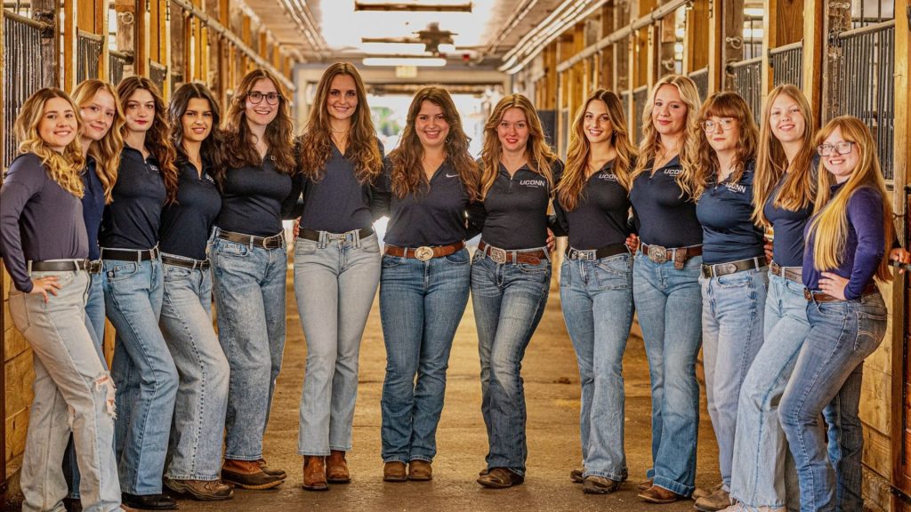 The Dressage Team posing for a photo inside of a horse unit.