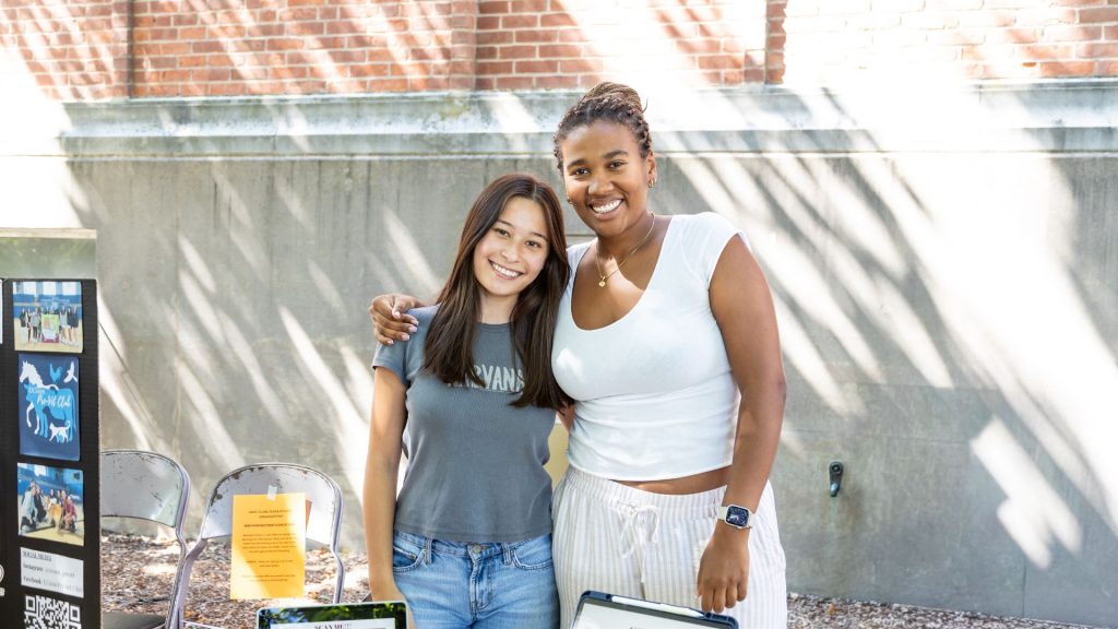 Two women stand side by side, smiling for a camera.